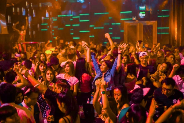 A vibrant Delhi nightclub filled with a lively crowd dancing under colorful lights and green neon accents, creating an energetic nightlife atmosphere.