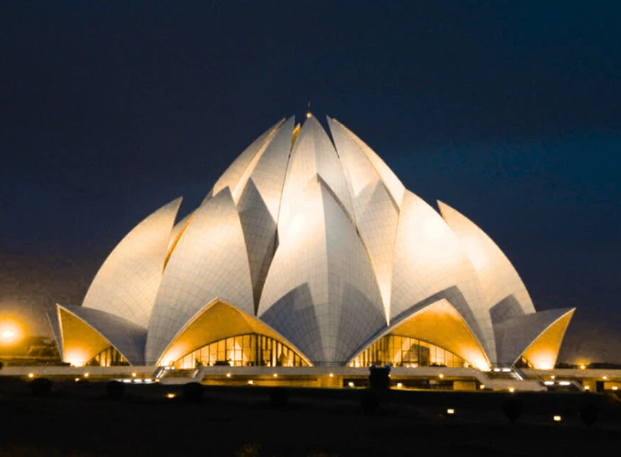 Illuminated Lotus Temple at night in Delhi, India