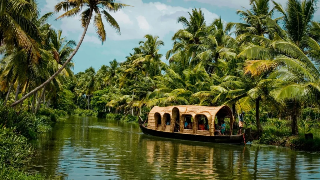 Traditional houseboat cruising through Kerala backwaters surrounded by lush green palm trees