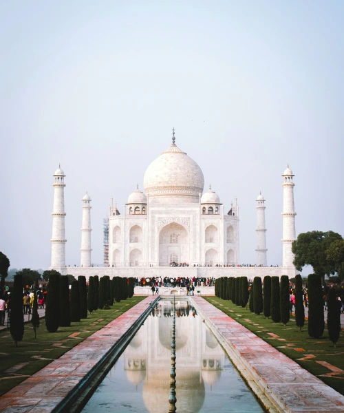 Front view of the Taj Mahal with reflecting pool and visitors in Agra, India
